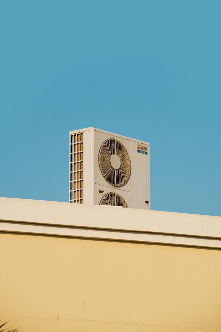 A technician measures a home's interior temperature near a large living room window.