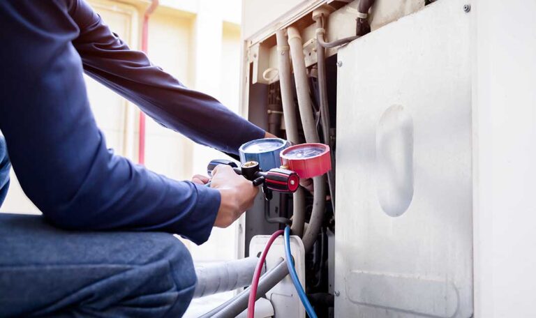 A homeowner swapping out a pleated HVAC air filter next to a household furnace unit.