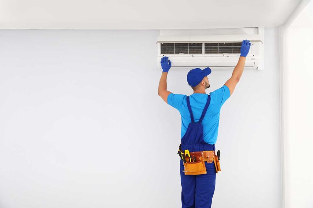 Man holding energy bill while adjusting digital thermostat in a cozy living room.