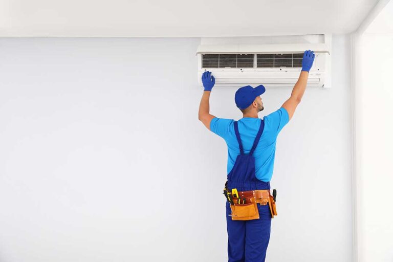 Man holding energy bill while adjusting digital thermostat in a cozy living room.